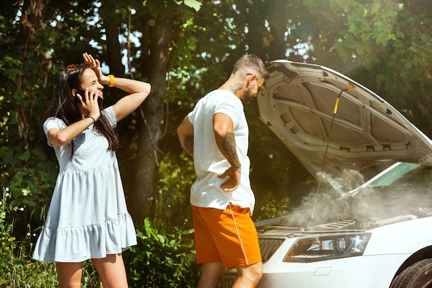 Young couple traveling on the car in sunny day