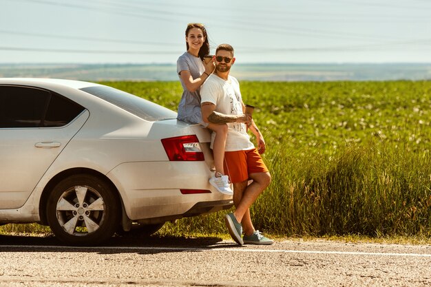 Young couple traveling on the car in sunny day