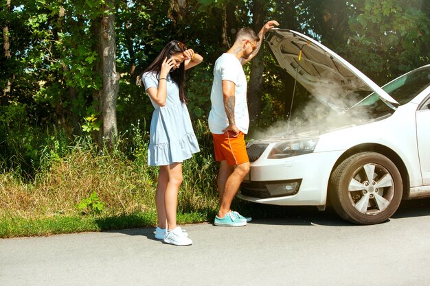 Young couple traveling on the car in sunny day