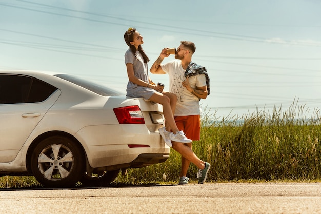 Young couple traveling on the car in sunny day