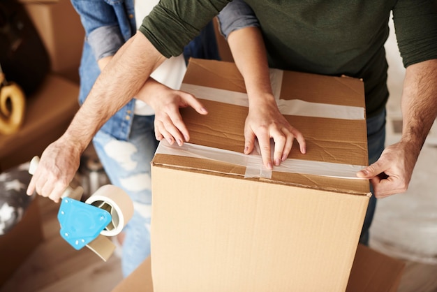 Young couple unpacking moving boxes in new flat