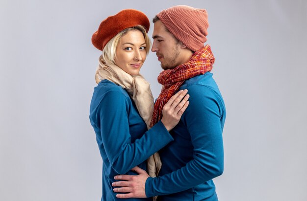 Young couple on valentines day wearing hat with scarf hugged each other isolated on white background