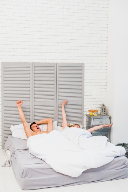 Young couple waking up in bed 