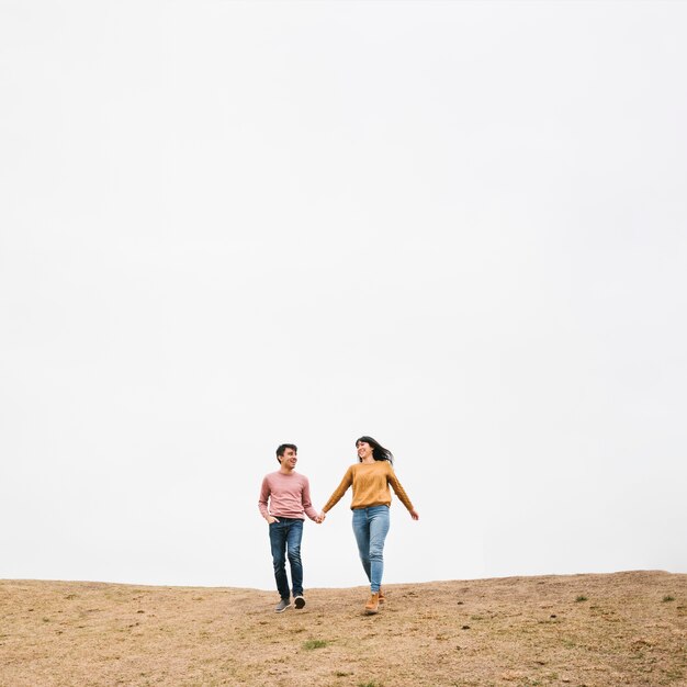 Young couple walking holding hands