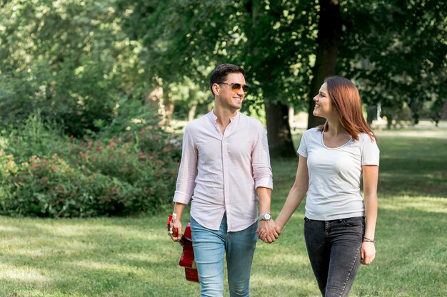 Young couple walking through green field 