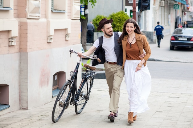 Young couple walking with bicycle and hugging