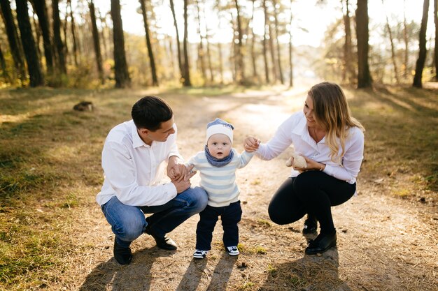 Free photo a young couple walks in the woods with a little boy