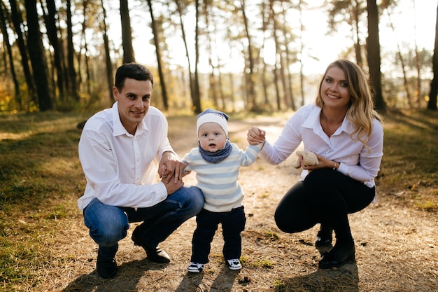 A young couple walks in the woods with a little boy