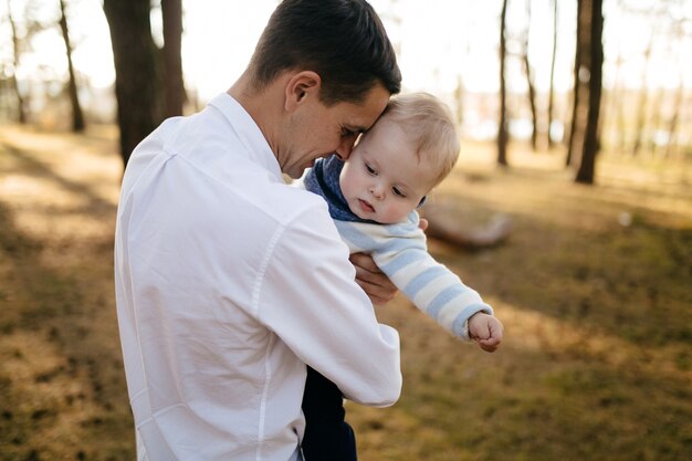 若いカップルが小さな男の子と森の中を歩く