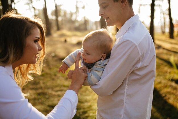 A young couple walks in the woods with a little boy