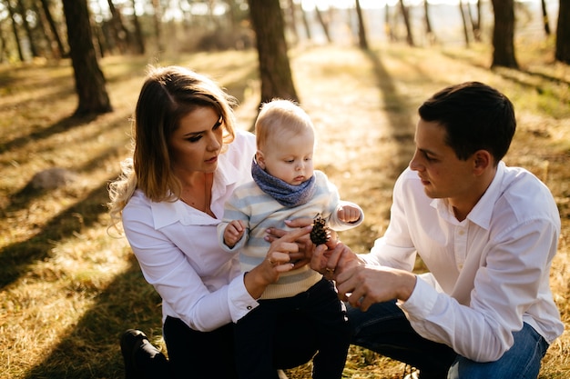 A young couple walks in the woods with a little boy