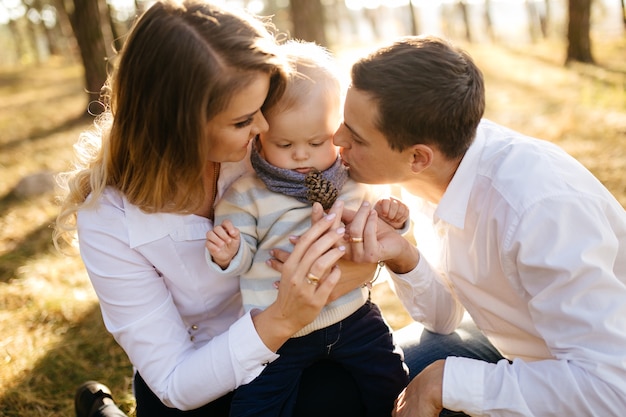 A young couple walks in the woods with a little boy