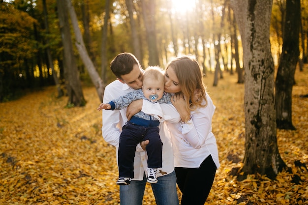 A young couple walks in the woods with a little boy