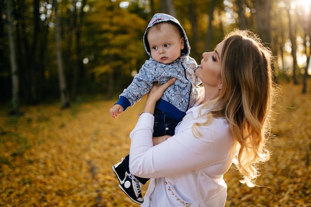 若いカップルが小さな男の子と森の中を歩く