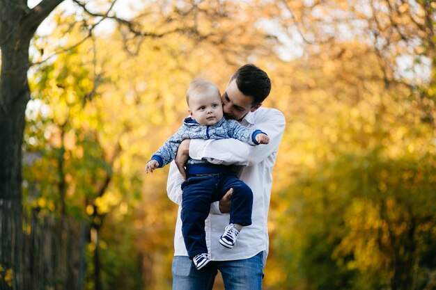 若いカップルが小さな男の子と森の中を歩く