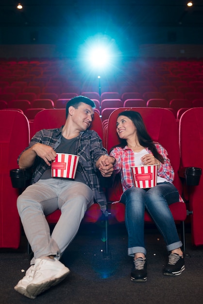 Молодая пара смотрит фильм в кино