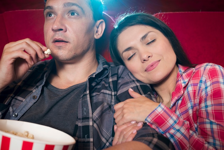 Free Photo young couple watching movie in cinema