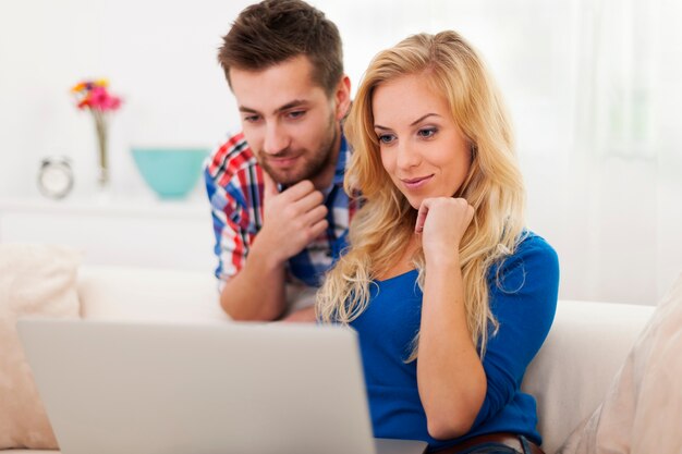 コンピューターで何かを見ている若いカップル