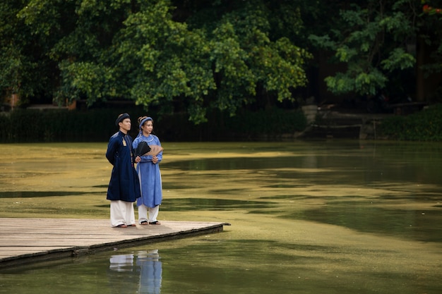 Free photo young couple wearing ao dai costume