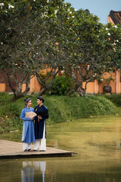 Free photo young couple wearing ao dai costume