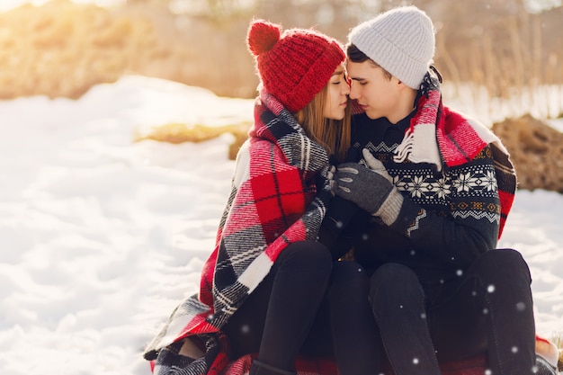 Young couple wearing blanket on a snowy field