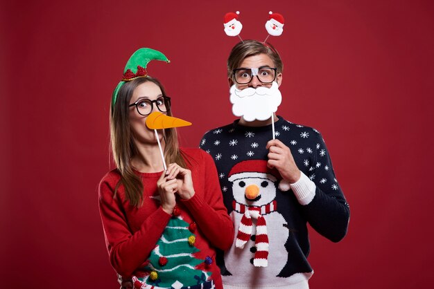 奇妙なクリスマスの服を着た若いカップル