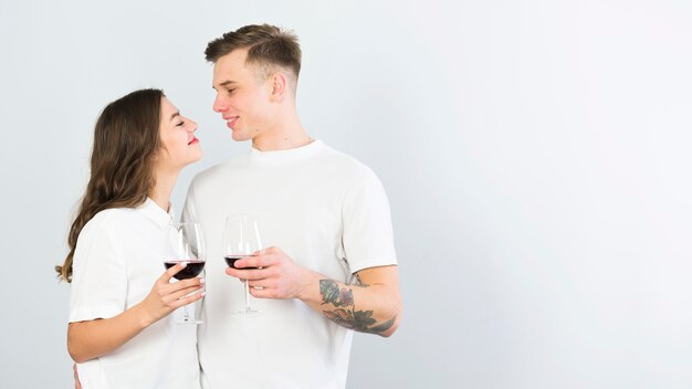 Young couple in white drinking wine