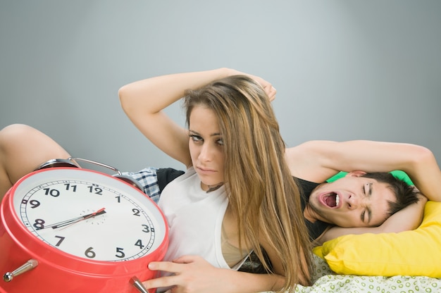Young couple with alarm clock