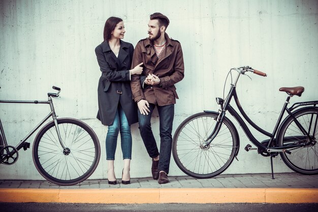 Young couple with a bicycle opposite city