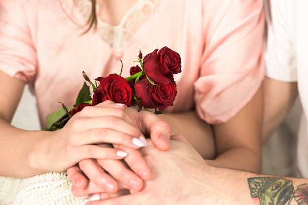 Free photo young couple with flowers holding hands