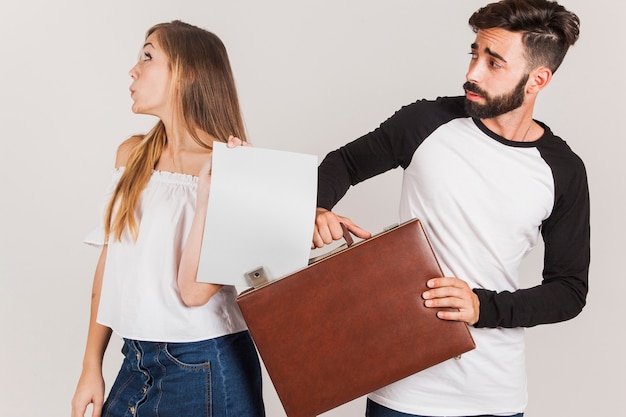 Young couple with paper and suitcase