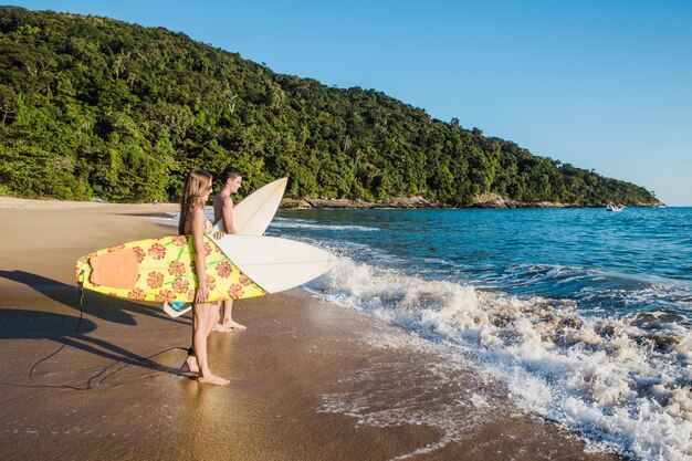 Young couple with surfboards