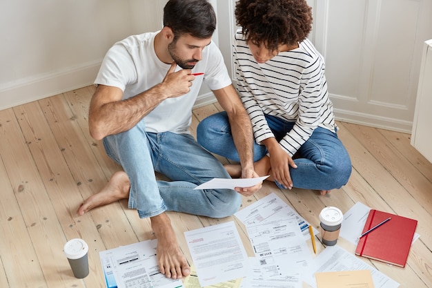 Free photo young couple working at home together on floor