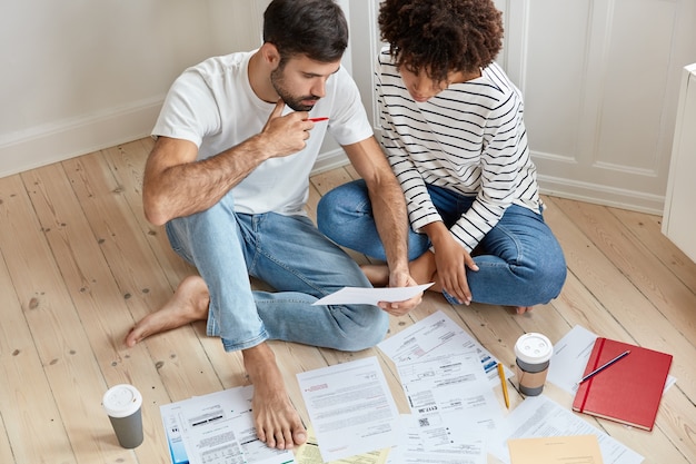 young couple working at home together on floor