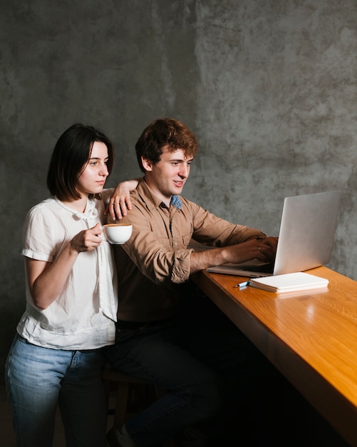 Free photo young couple working on laptop