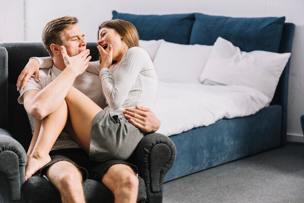 Young couple yawning in armchair 