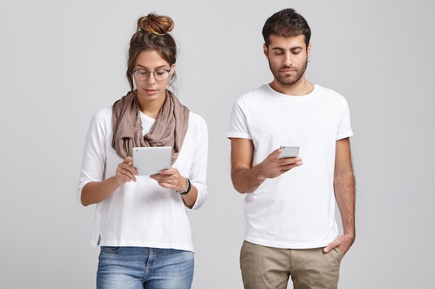 Young coworkers holding phone and tablet