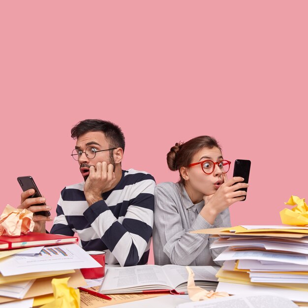 Young coworkers sitting at desk with documents