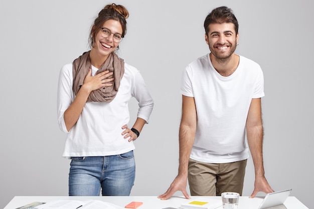 Young coworkers standing near desk