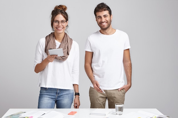 Young coworkers standing near desk