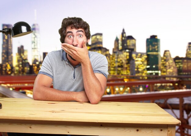 young crazy man on a table surprised expression