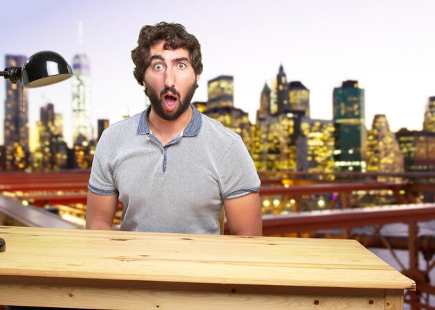 young crazy man on a table surprised expression