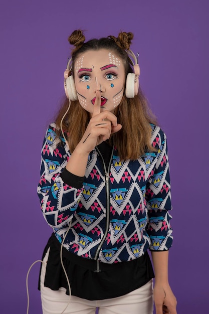 Young creative girl wearing fantasy makeup and gesture silent. High quality photo