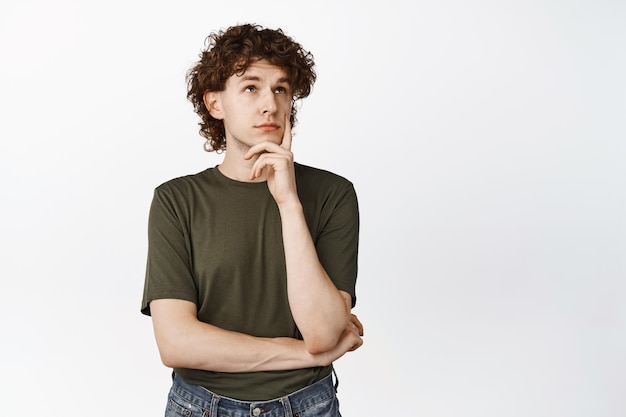Young Curly Guy Thinking Looking Up Thoughtful Making Decision Standing Over White Background