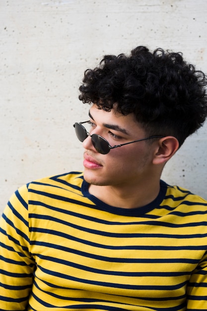 Free photo young curly male in sunglasses and striped shirt