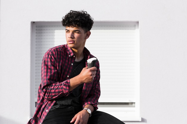 Free photo young curly man in plaid shirt with ice cream