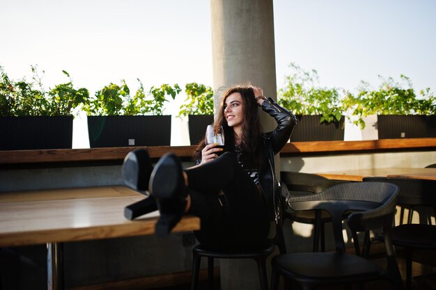 Free photo young curly woman enjoying her wine in a bar