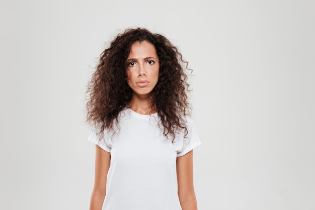 Giovane donna riccia che esamina la macchina fotografica