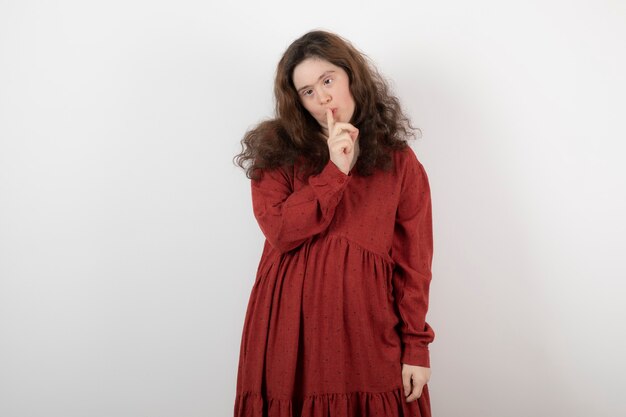 young cute woman with down syndrome standing and showing silent sign.