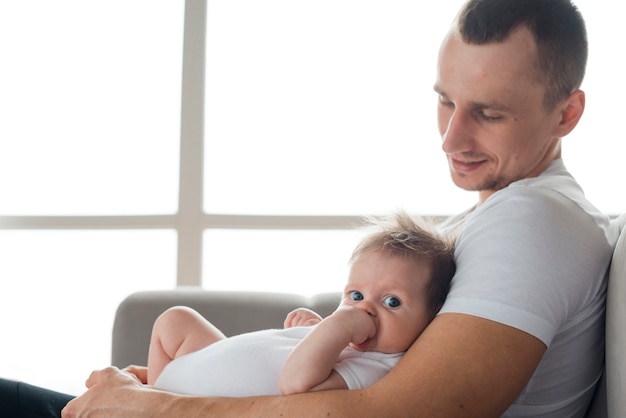 Young dad embracing child at home